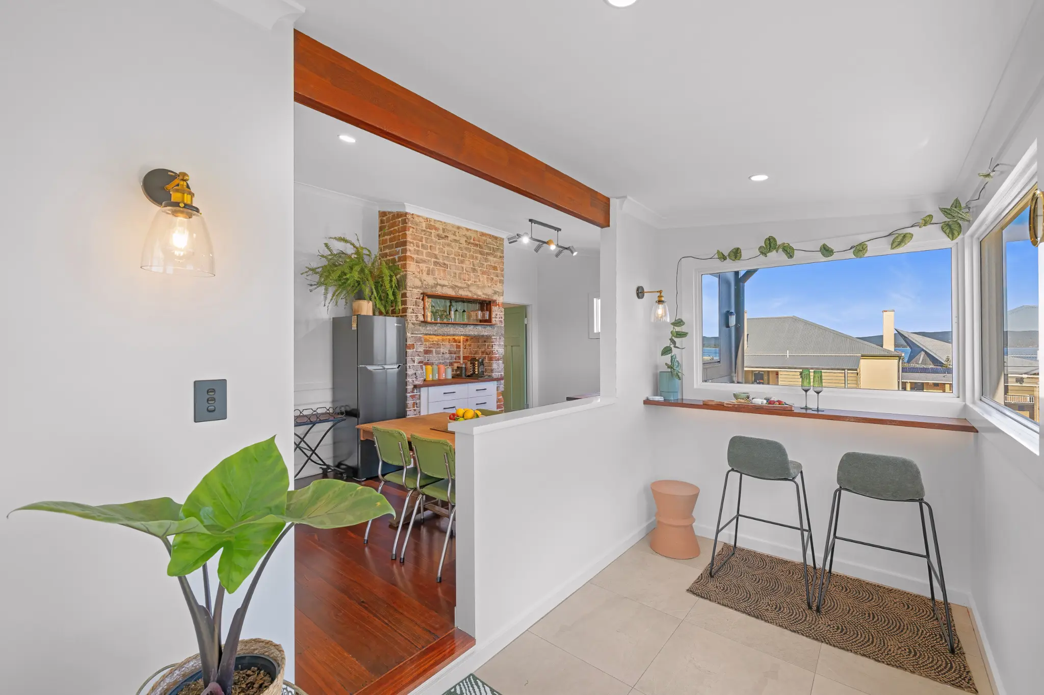 View bar with harbour outlook connecting to kitchen and dining area with exposed brick chimney beyond