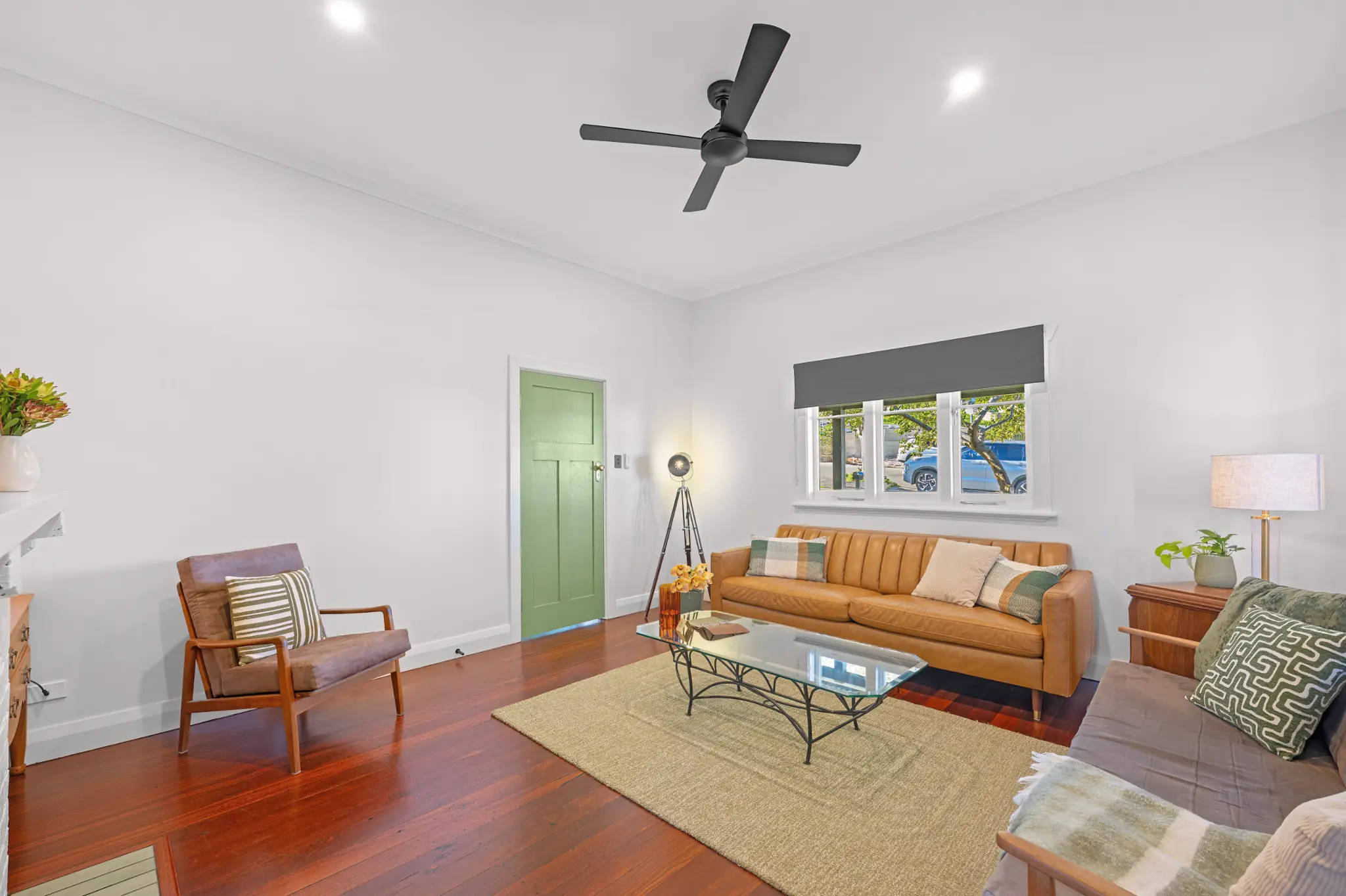 Spacious living room with leather sofa, high ceilings, jarrah floors and green internal door at The Yellow Door on Spencer